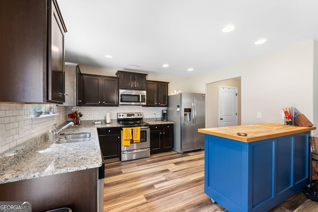 149 Pristine Dr, Locust Grove, GA 30248 - kitchen featuring stainless steel appliances, tasteful backsplash, light wood-style floors, dark brown cabinets, and butcher block counters