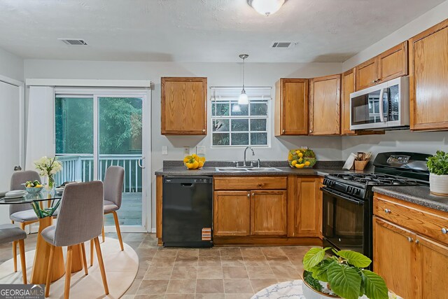 4634 Garden Hills Dr, Stone Mountain, GA 30083 - kitchen featuring black appliances, dark countertops, brown cabinets, and decorative light fixtures