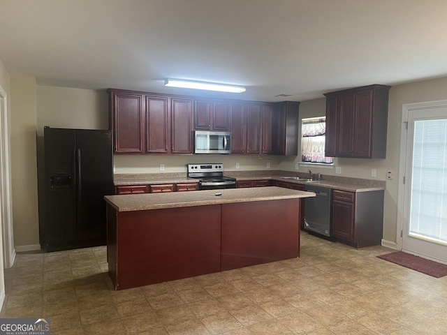 901 Broderick Cir, Warner Robins, GA 31088 - kitchen with stainless steel appliances, a sink, a center island, light countertops, and baseboards