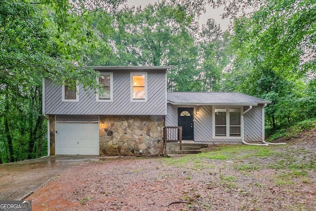 4905 Sandberg Ct, Stone Mountain, GA 30088 - split level home featuring driveway, stone siding, an attached garage, and a porch