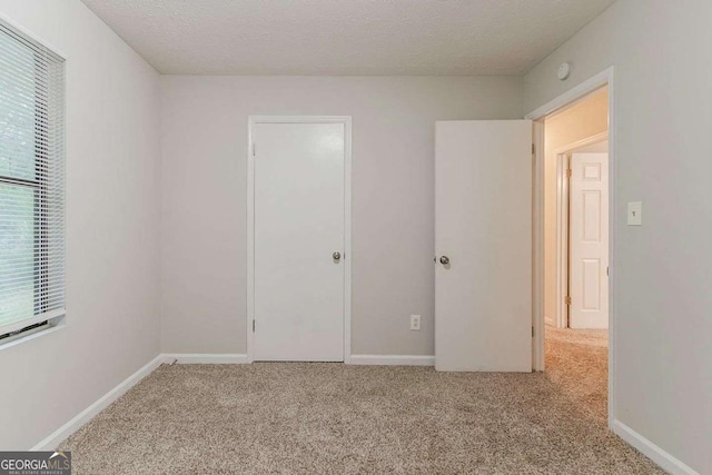 4905 Sandberg Ct, Stone Mountain, GA 30088 - unfurnished bedroom featuring carpet flooring, a textured ceiling, and baseboards