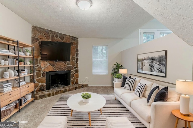 4905 Sandberg Ct, Stone Mountain, GA 30088 - living room featuring carpet flooring, a textured ceiling, a stone fireplace, lofted ceiling, and baseboards