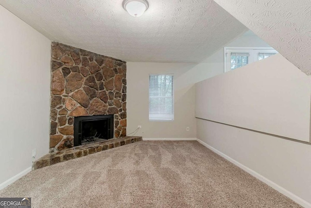 4905 Sandberg Ct, Stone Mountain, GA 30088 - unfurnished living room with a textured ceiling, carpet, plenty of natural light, vaulted ceiling, and a fireplace