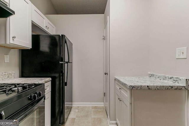 4905 Sandberg Ct, Stone Mountain, GA 30088 - kitchen with white cabinetry, light countertops, range hood, baseboards, and black appliances