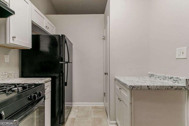 4905 Sandberg Ct, Stone Mountain, GA 30088 - kitchen featuring white cabinets, light countertops, ventilation hood, and black appliances