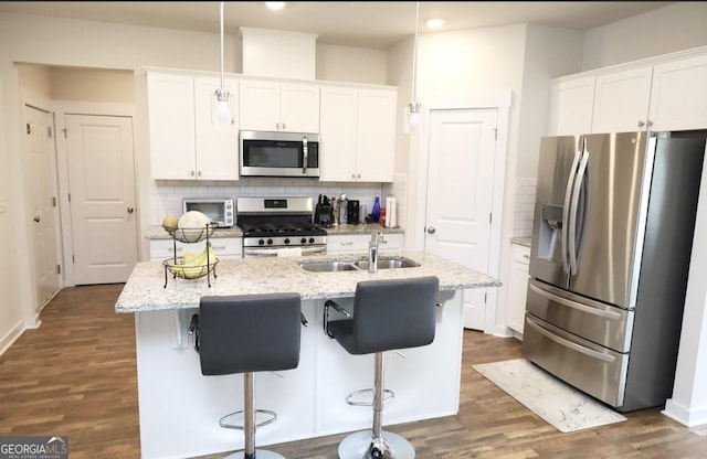 2845 Long Shadow Ct, Snellville, GA 30078 - kitchen featuring appliances with stainless steel finishes, a sink, white cabinetry, tasteful backsplash, and a kitchen island with sink