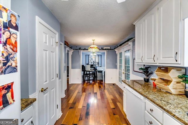 2200 E Lake Rd, Mcdonough, GA 30252 - kitchen with white dishwasher, white cabinets, hardwood / wood-style floors, a textured ceiling, and wainscoting
