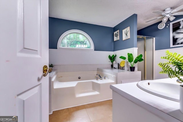 2200 E Lake Rd, Mcdonough, GA 30252 - bathroom featuring a bath, ceiling fan, a wainscoted wall, a textured ceiling, and a stall shower