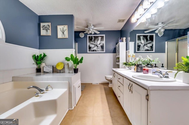 2200 E Lake Rd, Mcdonough, GA 30252 - full bath with ceiling fan, wainscoting, vanity, a garden tub, and a textured ceiling
