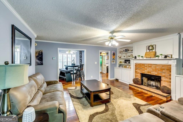 2200 E Lake Rd, Mcdonough, GA 30252 - living area with ceiling fan, ornamental molding, wood finished floors, a brick fireplace, and a textured ceiling