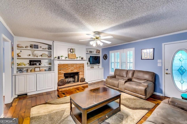 2200 E Lake Rd, Mcdonough, GA 30252 - living area featuring ornamental molding, hardwood / wood-style flooring, a ceiling fan, a textured ceiling, and built in shelves