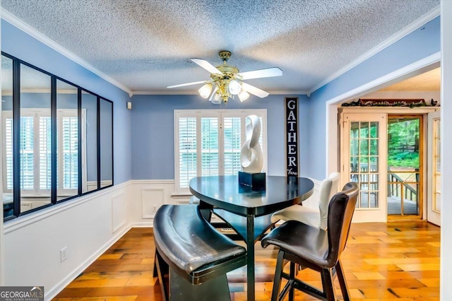 2200 E Lake Rd, Mcdonough, GA 30252 - dining area with hardwood / wood-style floors, a textured ceiling, ceiling fan, ornamental molding, and wainscoting