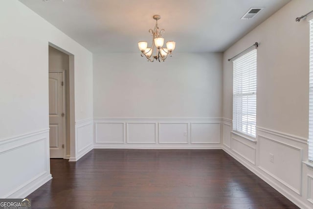 385 Broadmoor Dr, Braselton, GA 30517 - spare room featuring plenty of natural light, a chandelier, wainscoting, dark wood finished floors, and a decorative wall