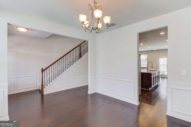 385 Broadmoor Dr, Braselton, GA 30517 - unfurnished dining area featuring a decorative wall, stairs, dark wood-type flooring, a chandelier, and wainscoting