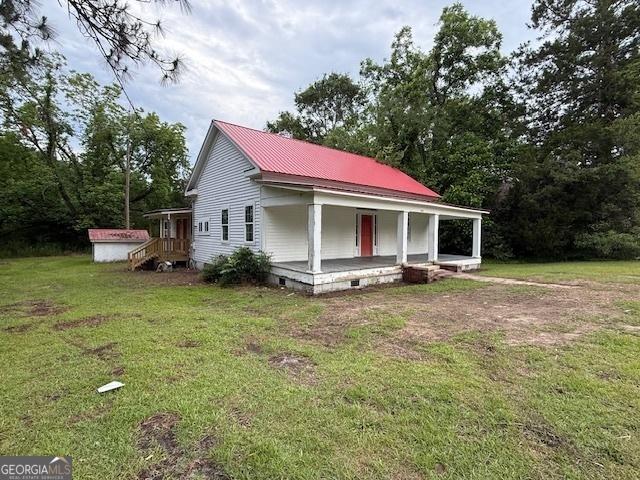 9610 Ga Highway 242, Harrison, GA 31035 - view of front of home featuring a porch, a front yard, and metal roof