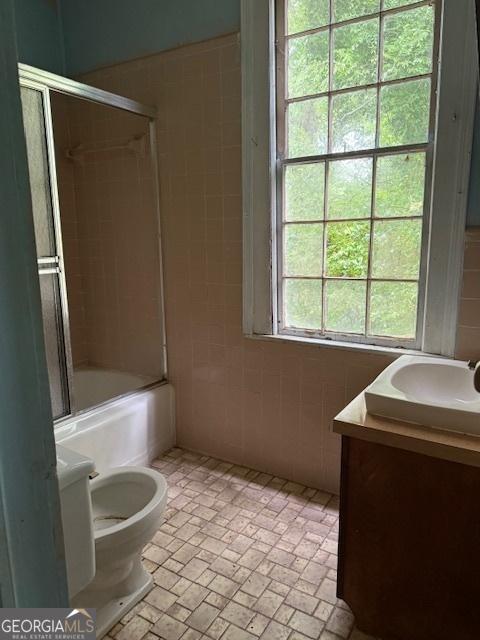 9610 Ga Highway 242, Harrison, GA 31035 - bathroom with vanity, tile walls, toilet, shower / bath combination with glass door, and brick patterned flooring