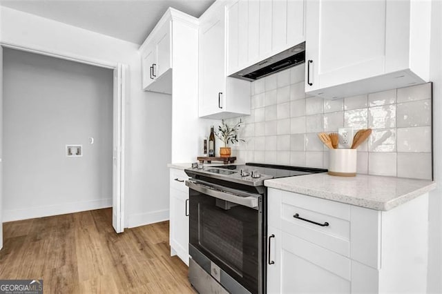5666 Fawn Dr, Powder Springs, GA 30127 - kitchen featuring stainless steel electric range oven, under cabinet range hood, baseboards, decorative backsplash, and white cabinetry