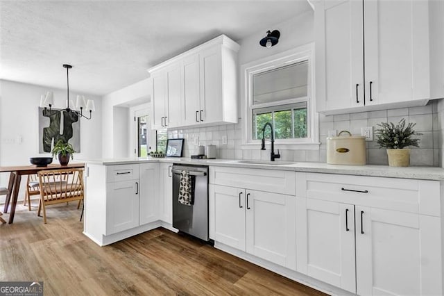 5666 Fawn Dr, Powder Springs, GA 30127 - kitchen featuring dishwasher, a sink, wood finished floors, light countertops, and decorative backsplash