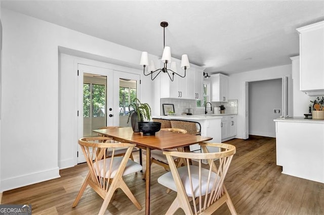 5666 Fawn Dr, Powder Springs, GA 30127 - dining area with wood finished floors, a chandelier, plenty of natural light, and french doors