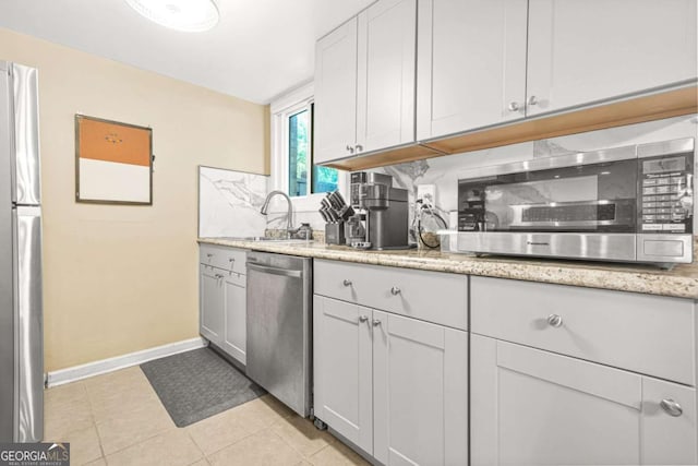 2952 N Dekalb Dr Unit C, Atlanta, GA 30340 - kitchen with appliances with stainless steel finishes, decorative backsplash, light stone counters, light tile patterned floors, and white cabinetry