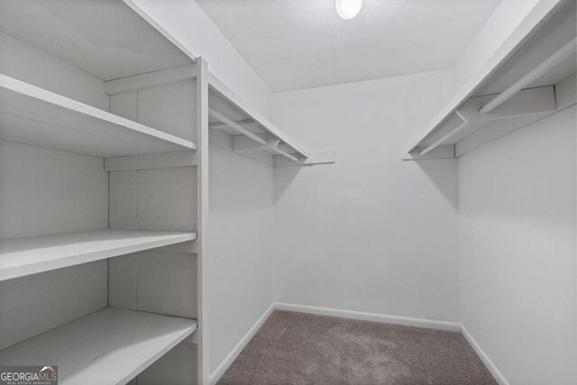 1150 Collier Rd NW Unit 6H, Atlanta, GA 30318 - unfurnished bedroom with carpet, baseboards, and a walk in closet