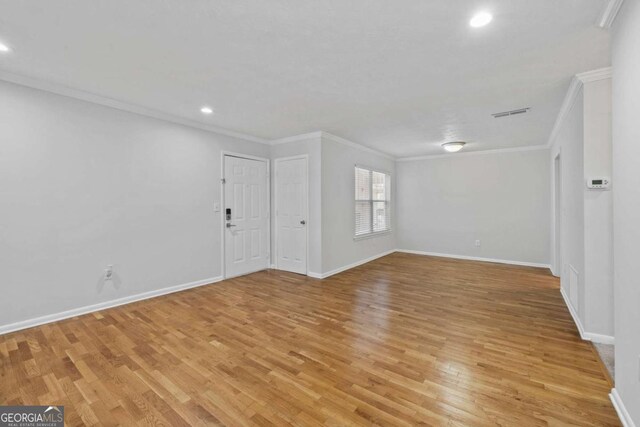1150 Collier Rd NW Unit 6H, Atlanta, GA 30318 - unfurnished living room with crown molding, light wood-style flooring, recessed lighting, and baseboards