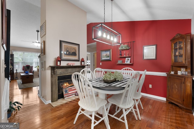 341 Jodeco Station Cir E, Stockbridge, GA 30281 - dining area featuring wood-type flooring, a fireplace with flush hearth, baseboards, and ceiling fan
