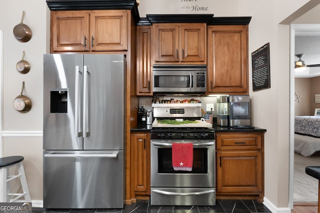 341 Jodeco Station Cir E, Stockbridge, GA 30281 - kitchen with stainless steel appliances, dark countertops, brown cabinetry, and baseboards