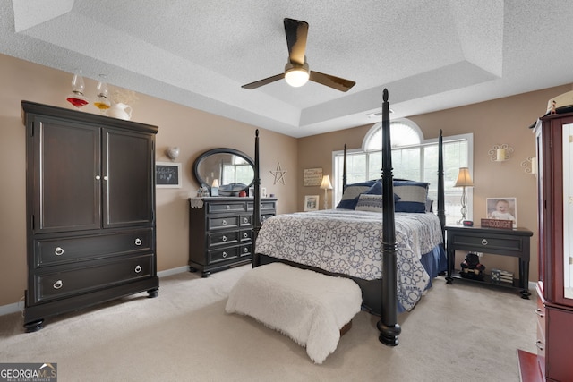 341 Jodeco Station Cir E, Stockbridge, GA 30281 - bedroom featuring a tray ceiling, light carpet, a textured ceiling, baseboards, and a ceiling fan