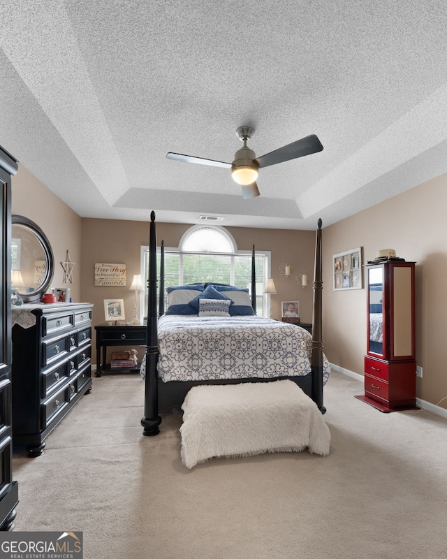 341 Jodeco Station Cir E, Stockbridge, GA 30281 - bedroom featuring light carpet, a tray ceiling, a textured ceiling, and a ceiling fan