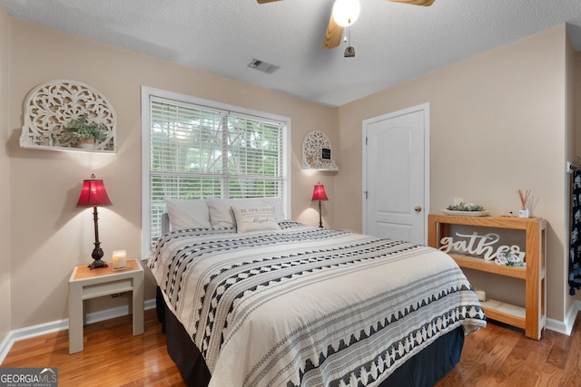 341 Jodeco Station Cir E, Stockbridge, GA 30281 - bedroom with light wood-type flooring, baseboards, a textured ceiling, and ceiling fan