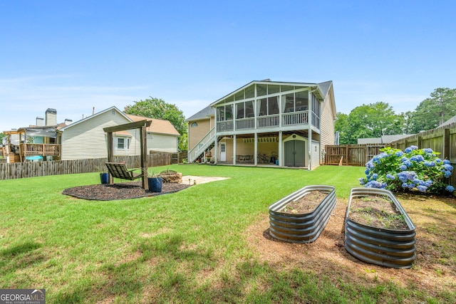341 Jodeco Station Cir E, Stockbridge, GA 30281 - rear view of property with a sunroom, a fire pit, stairway, and a vegetable garden
