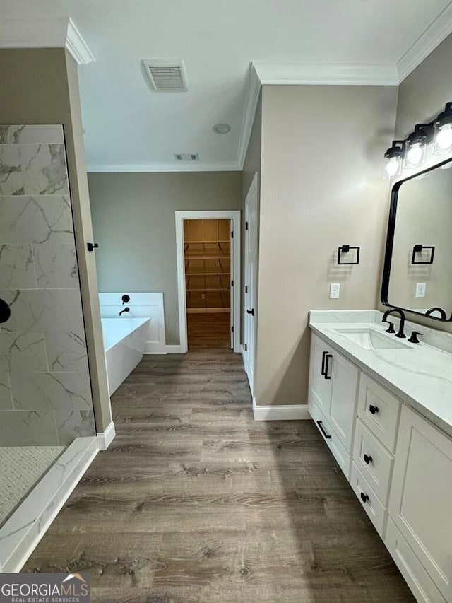 1231 Whipples Crossing Rd, Dudley, GA 31022 - bathroom with crown molding, a freestanding bath, vanity, a marble finish shower, and wood finished floors