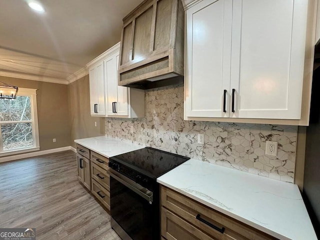 1231 Whipples Crossing Rd, Dudley, GA 31022 - kitchen featuring black electric range, light wood-style floors, backsplash, white cabinetry, and ornamental molding