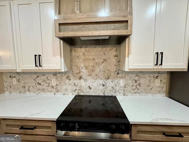 1231 Whipples Crossing Rd, Dudley, GA 31022 - kitchen with stainless steel electric stove, custom exhaust hood, decorative backsplash, white cabinetry, and light stone counters