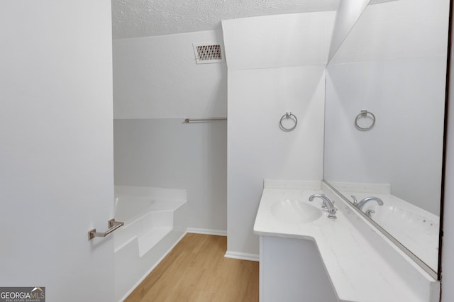 112 Valley Rd, Stockbridge, GA 30281 - bathroom featuring vanity, wood finished floors, a bath, and baseboards