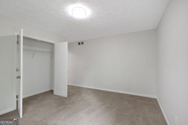 112 Valley Rd, Stockbridge, GA 30281 - unfurnished bedroom featuring carpet, a closet, a textured ceiling, and baseboards