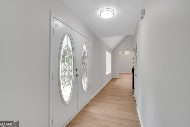 112 Valley Rd, Stockbridge, GA 30281 - foyer featuring light wood-style flooring, lofted ceiling, baseboards, and a textured ceiling