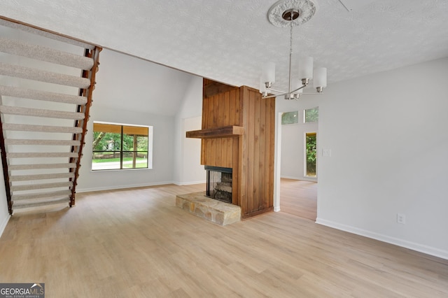 112 Valley Rd, Stockbridge, GA 30281 - unfurnished living room featuring plenty of natural light, light wood finished floors, a textured ceiling, and a multi sided fireplace