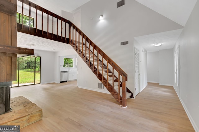 112 Valley Rd, Stockbridge, GA 30281 - unfurnished living room with stairway, wood finished floors, a sink, baseboards, and a high ceiling