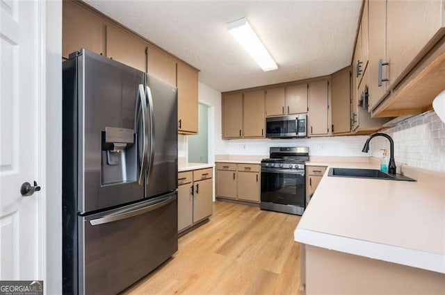 409 Cold Springs Ln, Mcdonough, GA 30252 - kitchen with appliances with stainless steel finishes, a sink, light wood-type flooring, light countertops, and backsplash