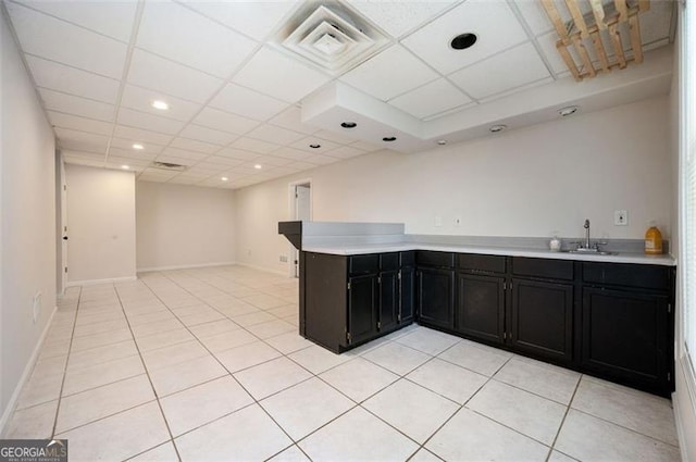 409 Cold Springs Ln, Mcdonough, GA 30252 - kitchen featuring dark cabinetry, a sink, light countertops, light tile patterned floors, and a drop ceiling