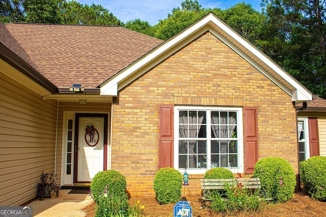 6830 Peeksville Rd, Mcdonough, GA 30252 - view of exterior entry featuring brick siding and a shingled roof