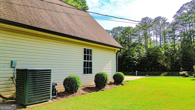 6830 Peeksville Rd, Mcdonough, GA 30252 - view of side of home featuring central air condition unit, a yard, and a shingled roof