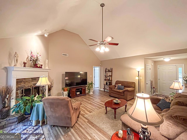 6830 Peeksville Rd, Mcdonough, GA 30252 - living area with wood finished floors, a ceiling fan, high vaulted ceiling, and a stone fireplace