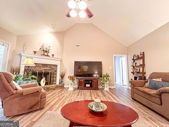 6830 Peeksville Rd, Mcdonough, GA 30252 - living area with a ceiling fan, light wood finished floors, vaulted ceiling, a stone fireplace, and baseboards