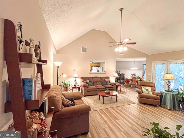 6830 Peeksville Rd, Mcdonough, GA 30252 - living area with ceiling fan, light wood-style flooring, high vaulted ceiling, and a chandelier