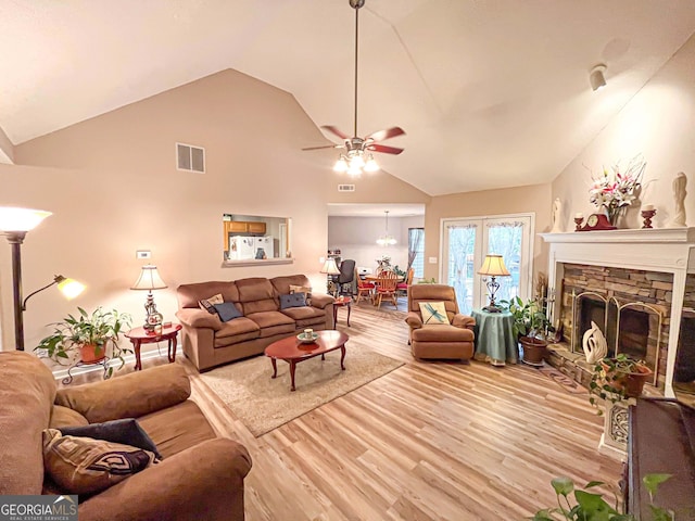 6830 Peeksville Rd, Mcdonough, GA 30252 - living room with light wood-style flooring, ceiling fan, a stone fireplace, and high vaulted ceiling