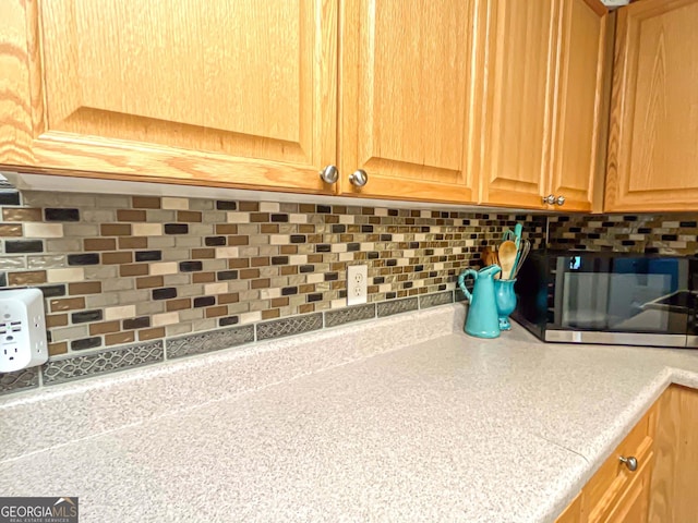 6830 Peeksville Rd, Mcdonough, GA 30252 - kitchen view of stainless steel microwave, light countertops, and decorative backsplash