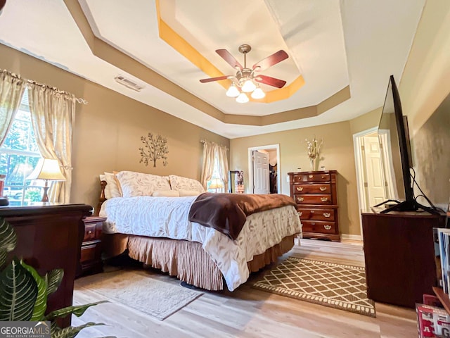 6830 Peeksville Rd, Mcdonough, GA 30252 - bedroom with a raised ceiling, light wood-type flooring, a walk in closet, and ceiling fan
